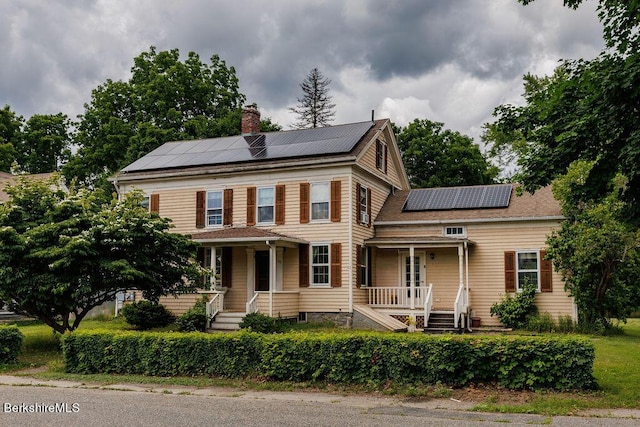 view of front facade featuring covered porch and solar panels