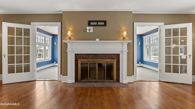 unfurnished living room with baseboard heating, crown molding, and hardwood / wood-style flooring