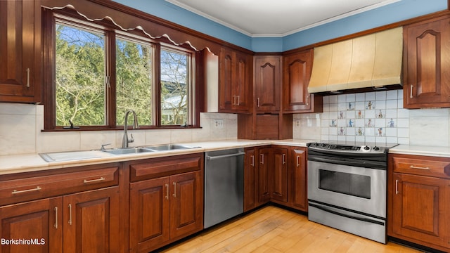 kitchen featuring tasteful backsplash, stainless steel appliances, light wood finished floors, custom exhaust hood, and light countertops