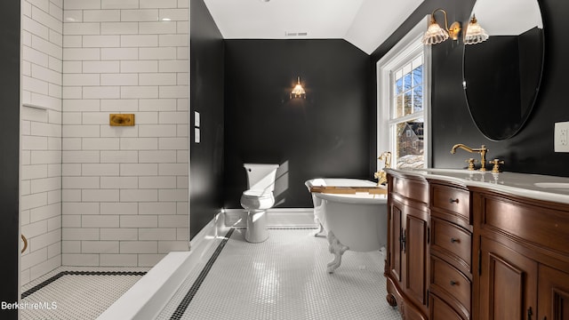 full bathroom with double vanity, a sink, tile patterned flooring, vaulted ceiling, and toilet