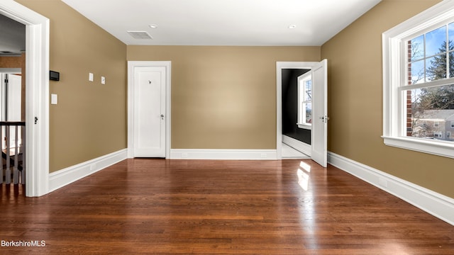 foyer entrance with wood finished floors, visible vents, and baseboards