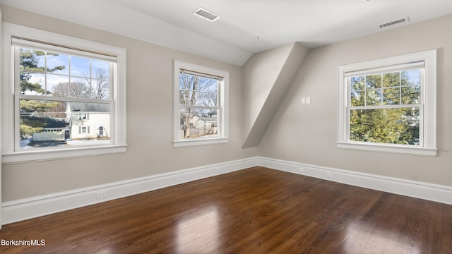 spare room featuring visible vents, plenty of natural light, and wood finished floors