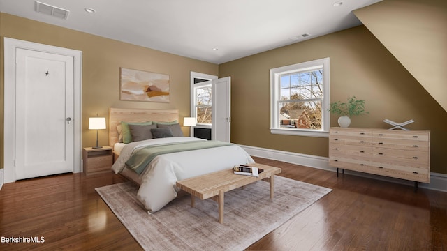 bedroom with visible vents, baseboards, and dark wood-style floors