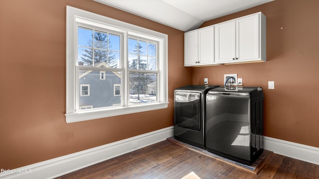 laundry room featuring washing machine and clothes dryer, dark wood-style floors, cabinet space, and baseboards