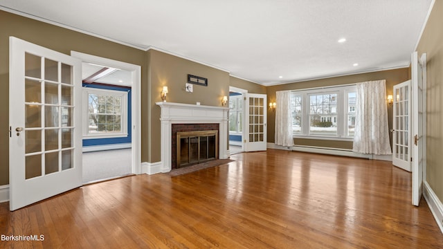 unfurnished living room featuring french doors, a brick fireplace, and a baseboard heating unit