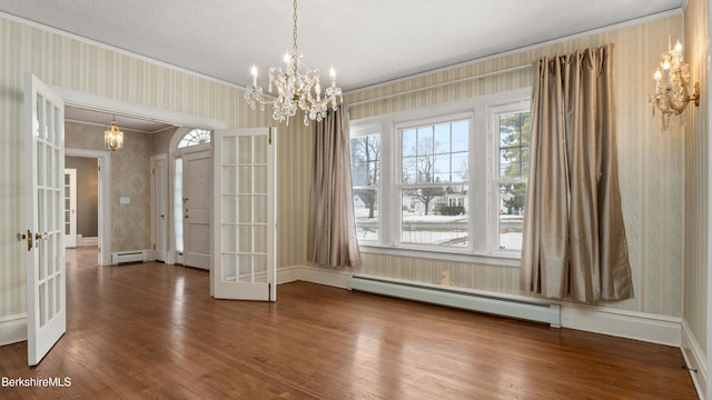 unfurnished dining area featuring wallpapered walls, french doors, an inviting chandelier, wood finished floors, and a baseboard radiator