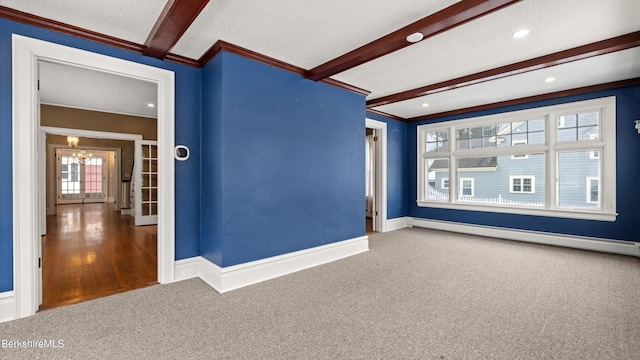 spare room featuring beam ceiling, baseboard heating, and carpet floors