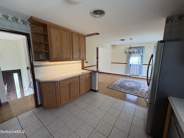 184 Mcintosh Dr, Pittsfield, MA 01201 - kitchen featuring freestanding refrigerator, light tile patterned flooring, open shelves, light countertops, and brown cabinets