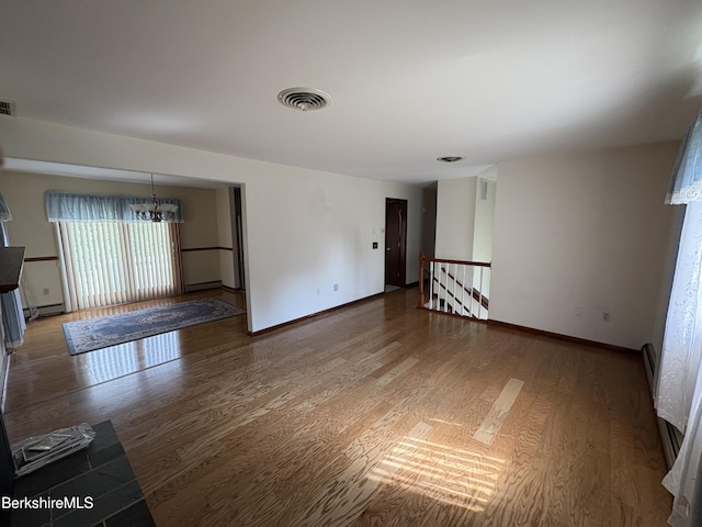 184 Mcintosh Dr, Pittsfield, MA 01201 - unfurnished room with wood finished floors, a chandelier, a baseboard heating unit, and a baseboard radiator