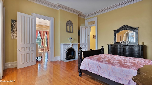 6 Eileen Dr, Rensselaer, NY 12144 - bedroom featuring crown molding, a fireplace with flush hearth, wood finished floors, and baseboards