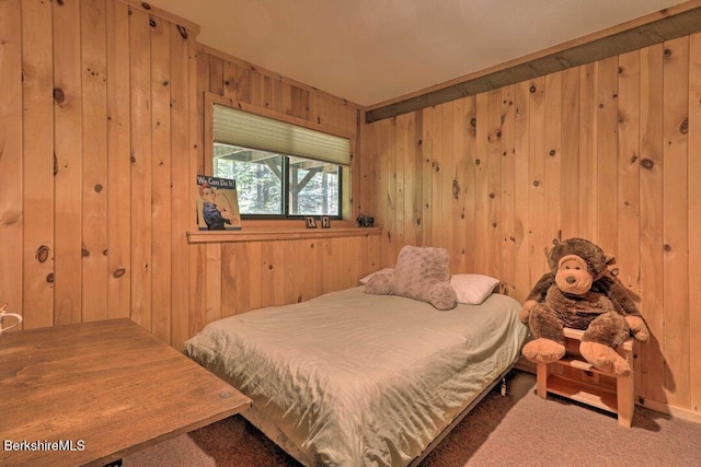 bedroom featuring wood walls and carpet