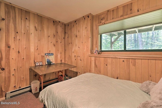 carpeted bedroom featuring wooden walls and a baseboard radiator