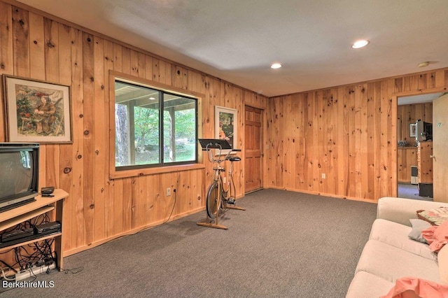 exercise area with wooden walls, baseboards, recessed lighting, and carpet flooring