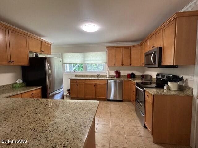 62 Maple Grove Dr, Pittsfield, MA 01201 - kitchen featuring appliances with stainless steel finishes, brown cabinets, light stone countertops, light tile patterned floors, and crown molding