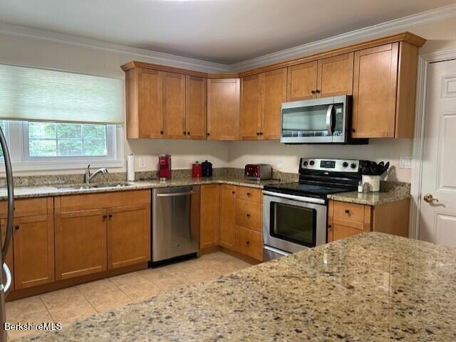 62 Maple Grove Dr, Pittsfield, MA 01201 - kitchen with stainless steel appliances, light stone countertops, brown cabinets, ornamental molding, and light tile patterned floors