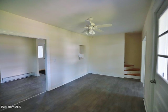 spare room with a wealth of natural light, dark hardwood / wood-style floors, baseboard heating, and ceiling fan