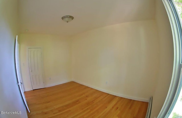 empty room featuring baseboard heating and light wood-type flooring