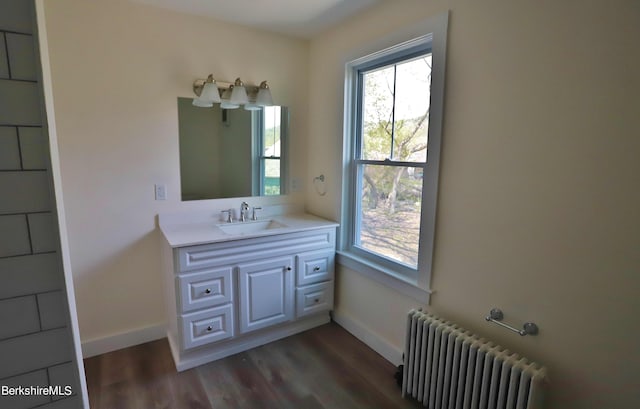 bathroom featuring hardwood / wood-style floors, vanity, a wealth of natural light, and radiator