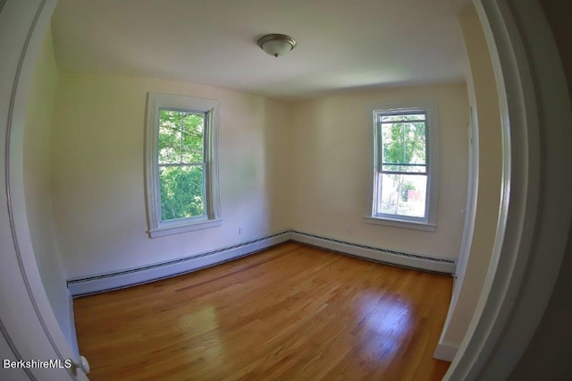 unfurnished room featuring light hardwood / wood-style floors and a baseboard radiator