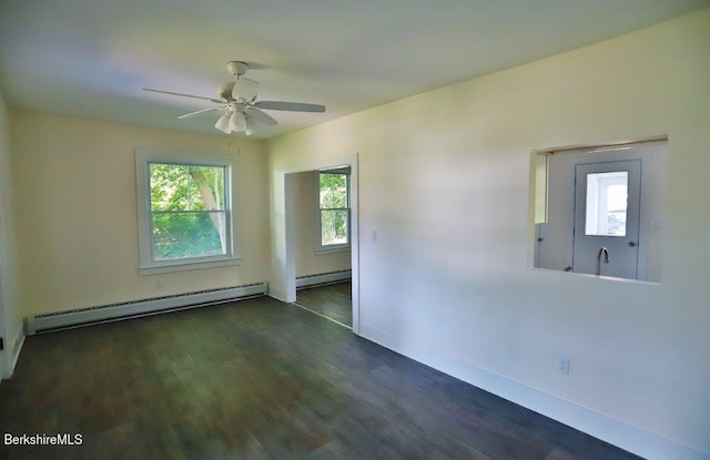 empty room featuring ceiling fan, dark hardwood / wood-style flooring, and a baseboard heating unit