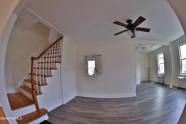 interior space with hardwood / wood-style flooring, ceiling fan, and radiator heating unit