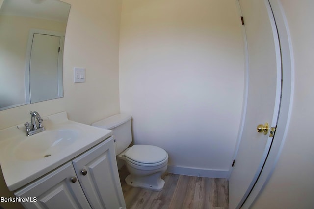 bathroom with toilet, vanity, and hardwood / wood-style flooring