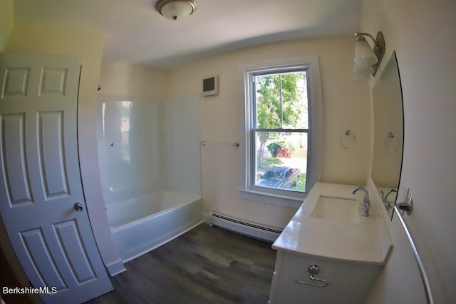 bathroom featuring baseboard heating, hardwood / wood-style floors, vanity, and bathtub / shower combination