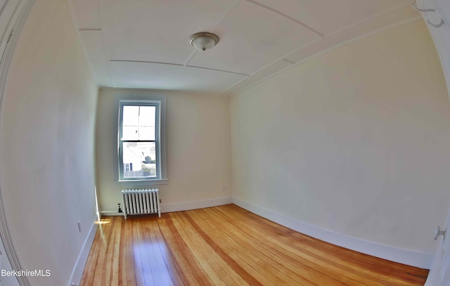 empty room with radiator and hardwood / wood-style floors