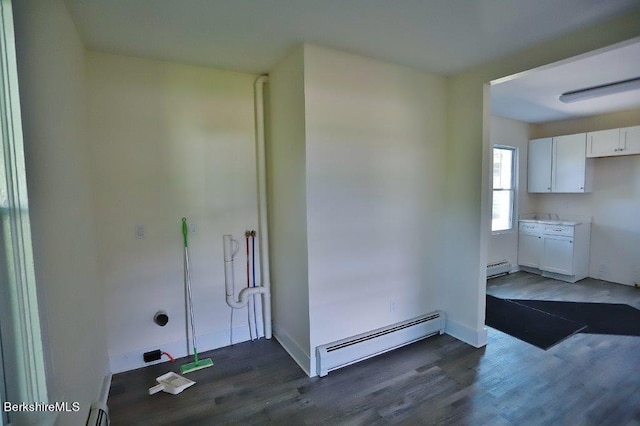 interior space featuring dark hardwood / wood-style floors, white cabinetry, and a baseboard heating unit