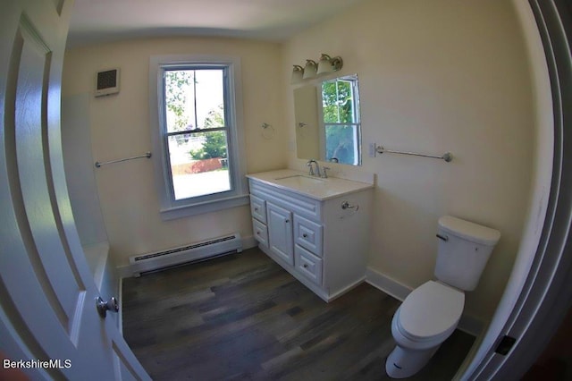 bathroom featuring vanity, toilet, wood-type flooring, and a baseboard heating unit