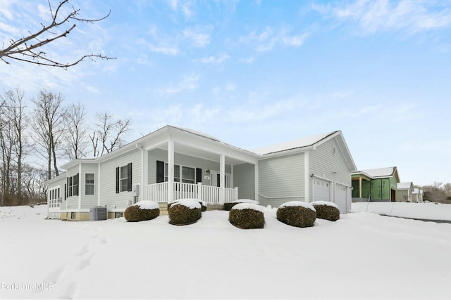 view of snowy exterior featuring a garage, a porch, and central air condition unit