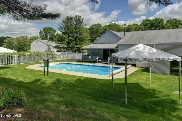 view of swimming pool with a fenced in pool, a fenced backyard, and a lawn