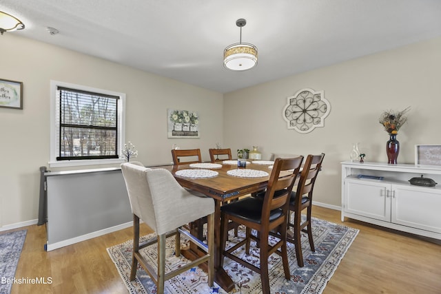 dining area featuring light wood-style flooring and baseboards