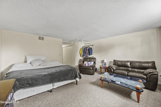 bedroom featuring a textured ceiling, a closet, carpet flooring, and visible vents