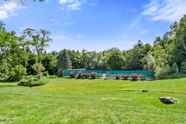 view of property's community featuring a yard and fence