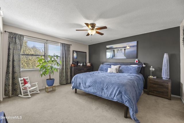 carpeted bedroom featuring a ceiling fan, a textured ceiling, and baseboards