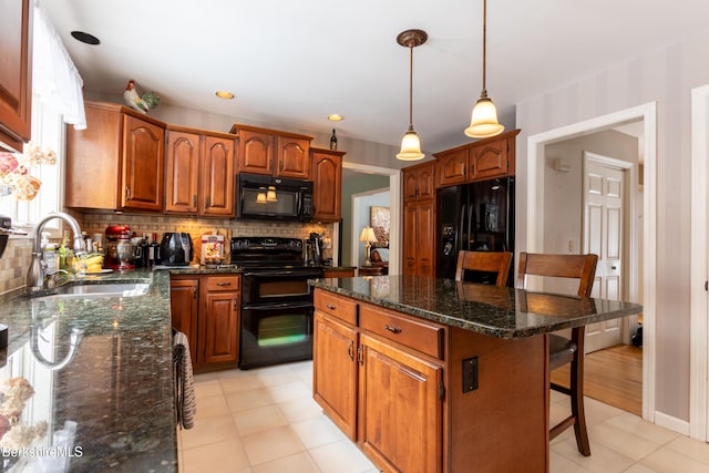 kitchen featuring sink, a kitchen breakfast bar, black appliances, a kitchen island, and decorative backsplash