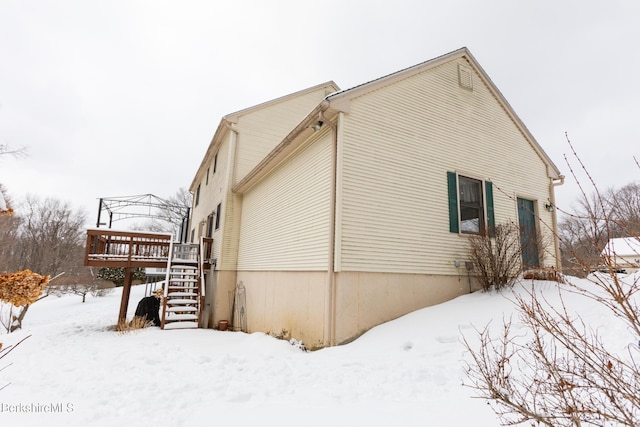 snow covered property with a wooden deck