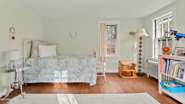 bedroom with radiator and hardwood / wood-style flooring