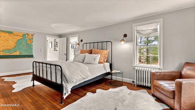 bedroom featuring radiator heating unit and hardwood / wood-style floors