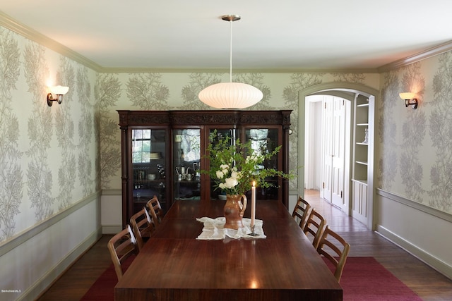 dining space with built in features, crown molding, and dark wood-type flooring