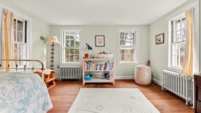 bedroom with radiator and light hardwood / wood-style flooring