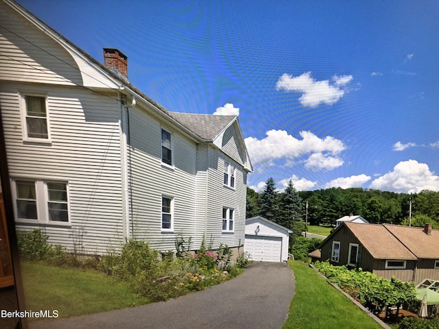 20 Summer St, Lee, MA 01238 - view of side of home with a garage, a yard, a chimney, and an outdoor structure