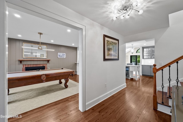 4 Woodlawn Dr, Williamstown, MA 01267 - entryway with a brick fireplace, baseboards, wood-type flooring, a chandelier, and billiards