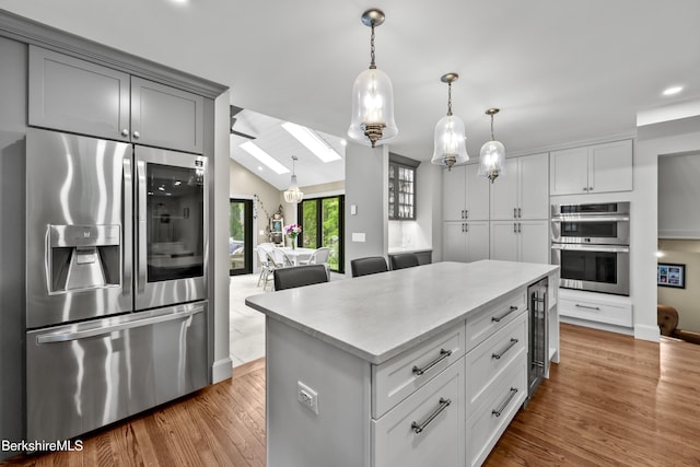 4 Woodlawn Dr, Williamstown, MA 01267 - kitchen with stainless steel appliances, a skylight, beverage cooler, light countertops, and a center island