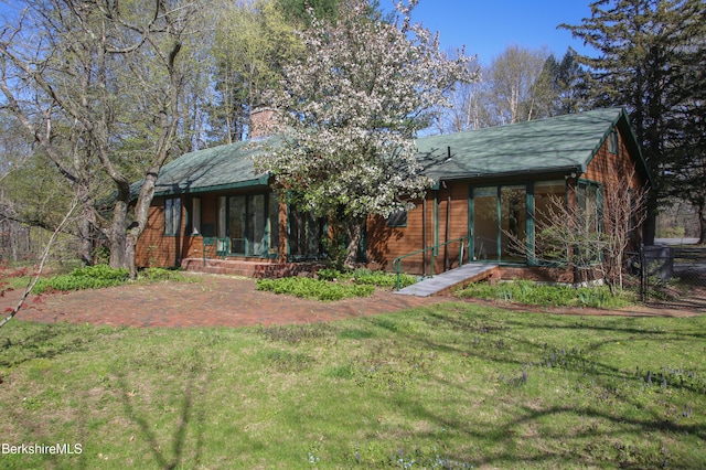 view of front of house featuring a front lawn and a chimney