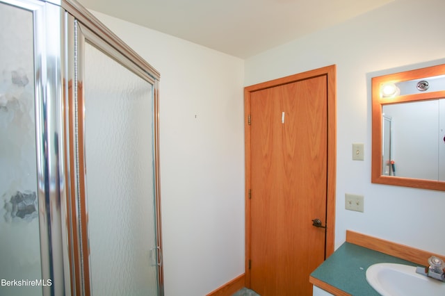 bathroom with vanity and a shower with door