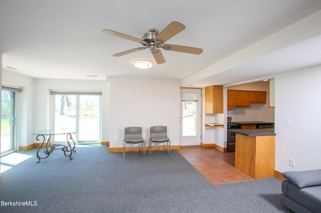 carpeted living room featuring baseboards and ceiling fan