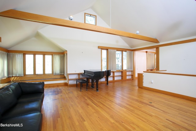 living room with light wood-style flooring and high vaulted ceiling