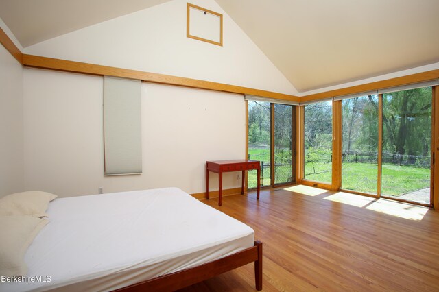 bedroom featuring access to outside, high vaulted ceiling, and wood finished floors